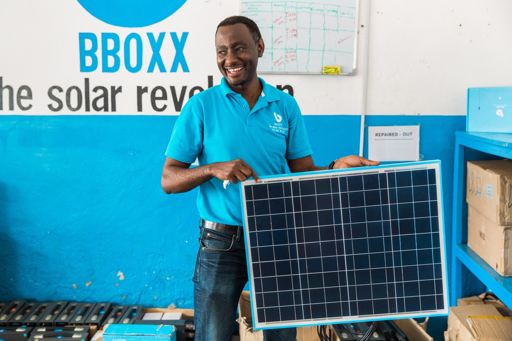 BBOXX employee holding solar panel