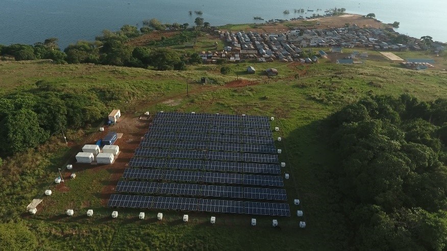 Overhead image of solar plant and African village in background