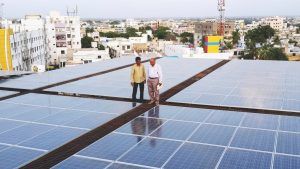 2 men standing on very large solar panelled roof